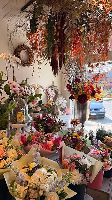 Inside the shop: buckets of fresh flowers under a hanging dried-flower installation